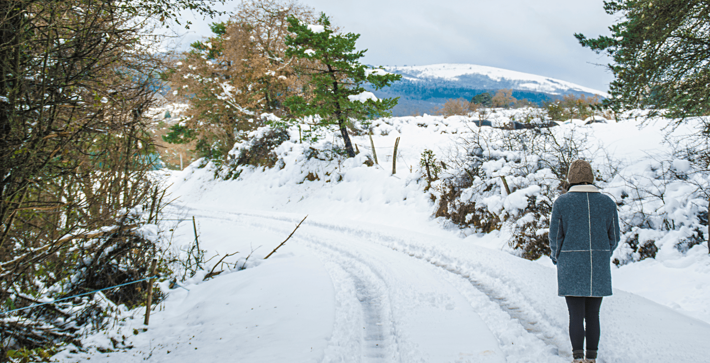 Person walks through snow in the scenic Cotswolds - Christmas holiday ideas