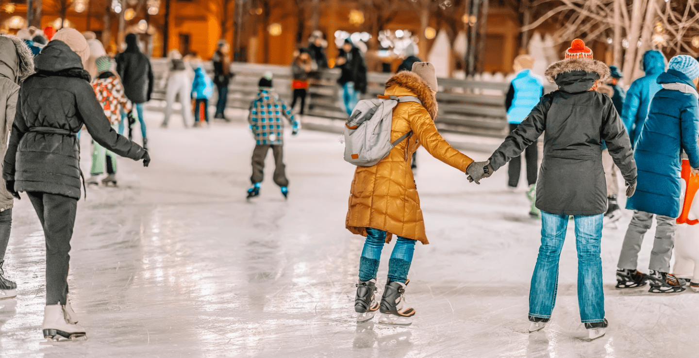 Winter wonderland people ice skating in big warm coats - Christmas holiday ideas